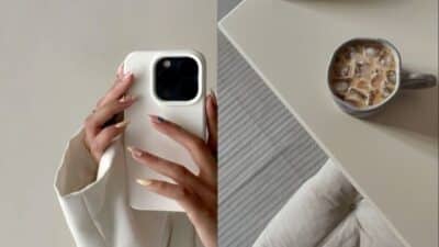 Hands with stylish nails holding smartphone, next to iced coffee on table. Minimalist lifestyle and tech vibes.