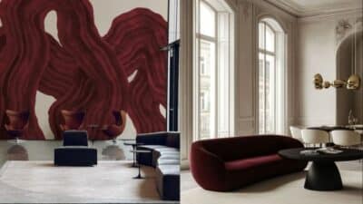 Modern living room with abstract mural, burgundy sofa, and contemporary furniture in natural light.