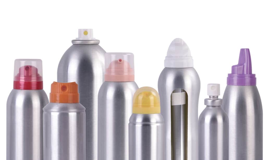 Various aerosol cans with colorful caps arranged in a group, showcasing diverse packaging styles.