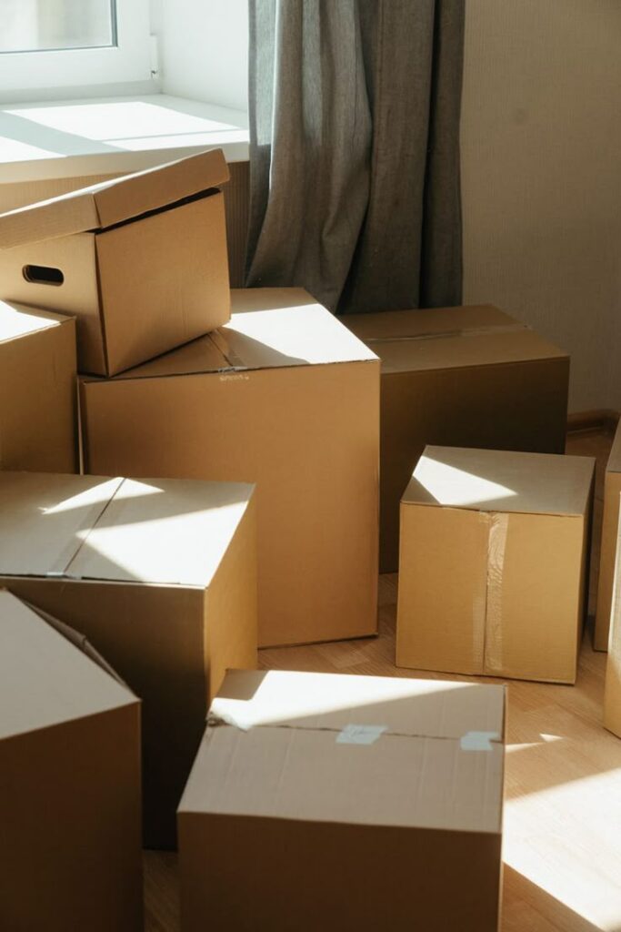 Cardboard boxes stacked in a sunlit room, ready for moving or storage.