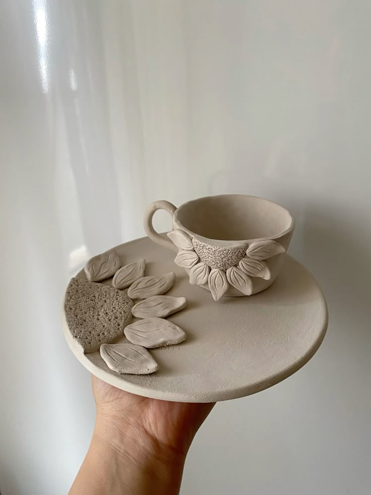 Handcrafted ceramic sunflower plate with matching cup, featuring delicate petal designs.