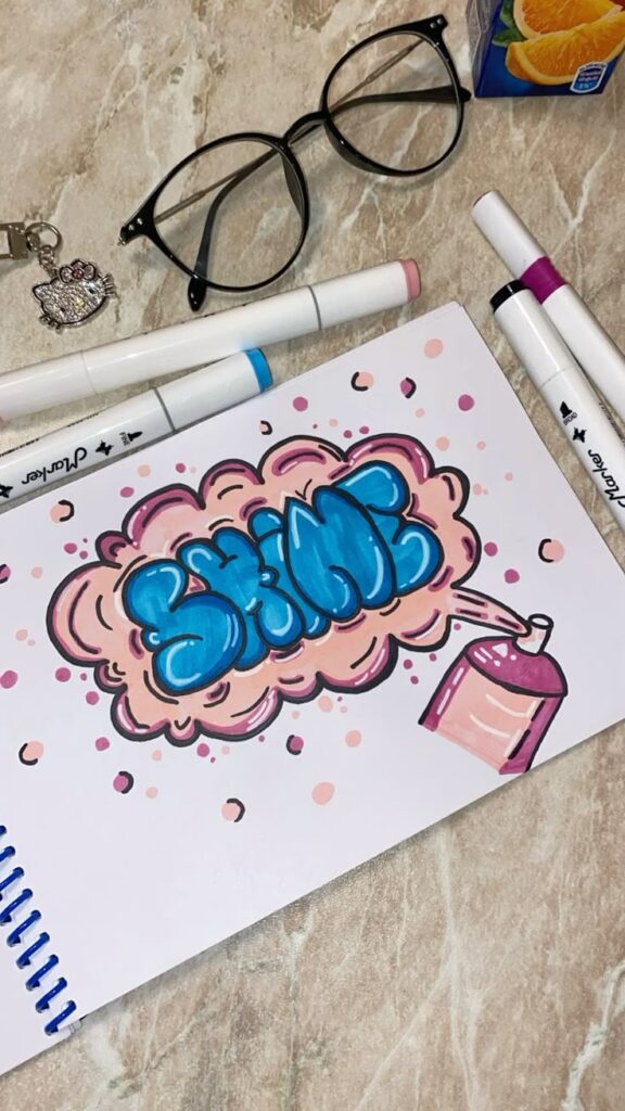Graffiti art with SHINE on paper, surrounded by markers, glasses, and a keychain on a marble table.
