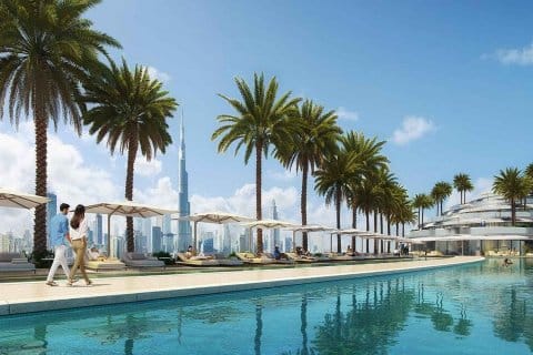 Luxurious poolside with palm trees and cityscape, featuring iconic skyscraper in the background under a clear blue sky.
