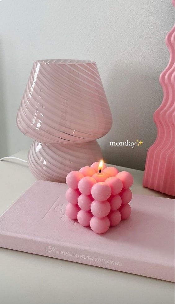 Pink bubble candle burning beside a pink lamp and journal on a white surface, with Monday✨ text. Cozy decor vibes.