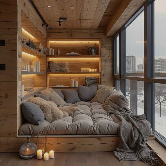 Cozy wooden nook with plush seating, throw pillows, candles, and city view, perfect for relaxation.