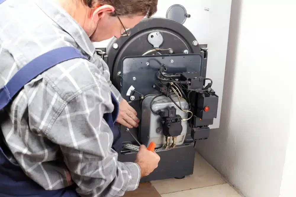 Technician servicing a gas furnace for maintenance and safety.