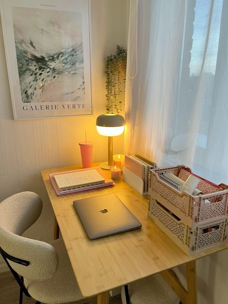 Cozy home office desk with laptop, open notebook, and warm lamp light creating a peaceful study environment.