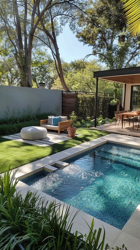 Modern backyard with a swimming pool, outdoor seating area, and lush greenery under a clear blue sky.