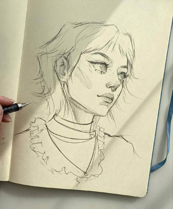 Hand-drawn sketch of a woman's portrait in a notebook, showcasing artistic pencil techniques.