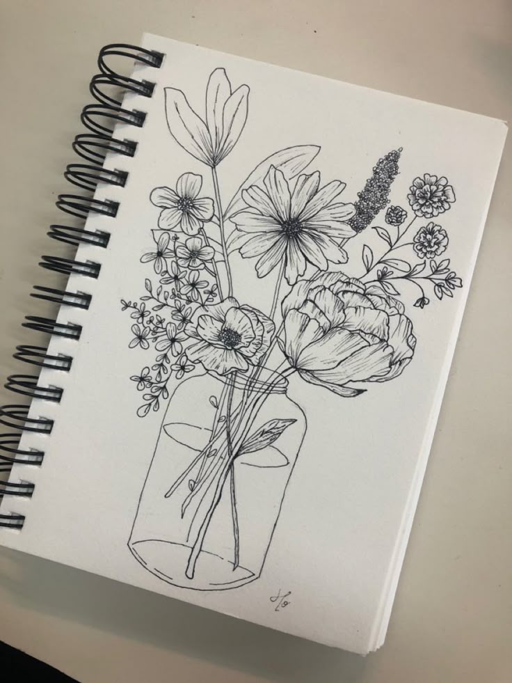 Sketch of flowers in a vase on a spiral-bound sketchpad, showcasing intricate line art.