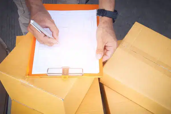 depositphotos_757177334-stock-photo-workers-check-invoices-shipping-customers Person checking shipment boxes with a clipboard outdoors, ensuring delivery accuracy and package safety. | Sky Rye Design Person checking shipment boxes with a clipboard outdoors, ensuring delivery accuracy and package safety.