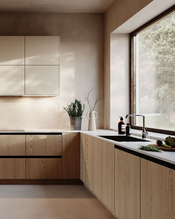 Modern kitchen with wooden cabinets, large window, and potted plants, creating a bright and airy atmosphere.