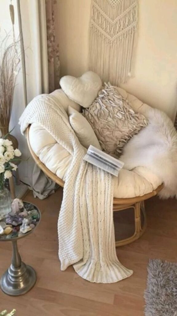 Cozy reading nook with a plush chair, cushions, a warm blanket, and a book, creating a calming, inviting atmosphere.