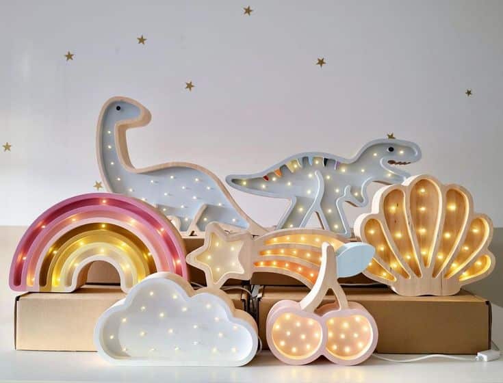 Children's decorative LED lamps in dinosaur, rainbow, cloud, and star shapes on a shelf. Perfect for kids' rooms.