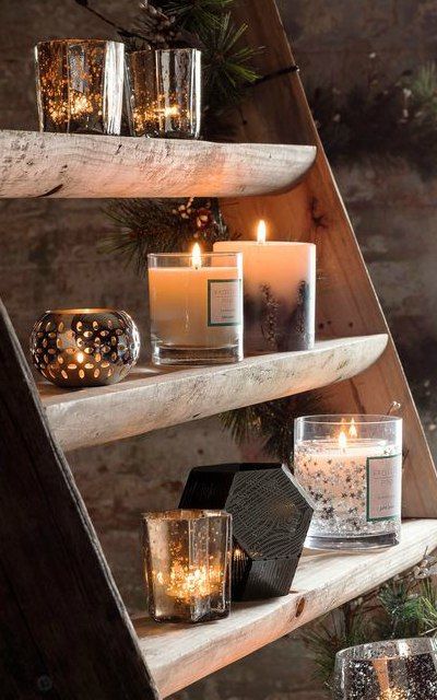 Rustic wooden shelves adorned with glowing candles in glass holders, creating a cozy and warm ambiance.