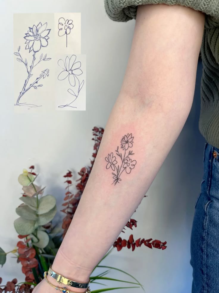 Minimalist floral tattoo on forearm, inspired by doodle sketches, with greenery in the background.