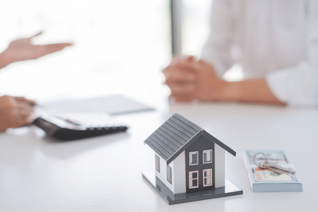 image Miniature house on desk with keys and cash, signifying real estate deal or home buying consultation. | Sky Rye Design Miniature house on desk with keys and cash, signifying real estate deal or home buying consultation.