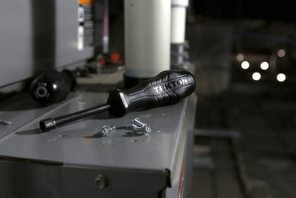 image Black TEKTON screwdriver and screws on a metal surface, essential tools for repairs and maintenance. | Sky Rye Design Black TEKTON screwdriver and screws on a metal surface, essential tools for repairs and maintenance.