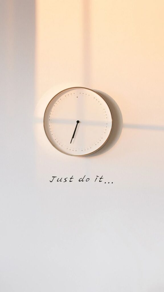 Minimalist clock with shadow on wall, motivational text Just do it below.