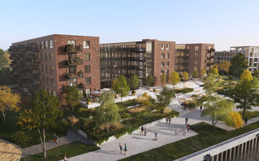 Modern apartment complex with landscaped gardens and people walking on paths under clear blue skies.