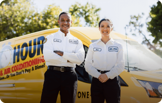 Two HVAC technicians standing in front of a branded yellow van, wearing uniforms, and smiling.