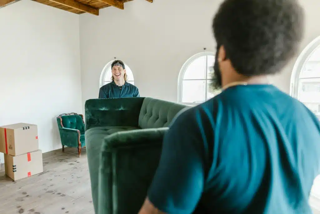 pexels-photo-7464676 People moving a green sofa in a bright room with boxes, focusing on teamwork and interior setup. | Sky Rye Design People moving a green sofa in a bright room with boxes, focusing on teamwork and interior setup.