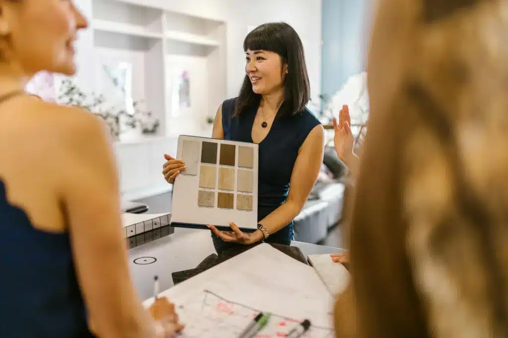 Interior designer presenting color swatches to clients in a modern office setting.