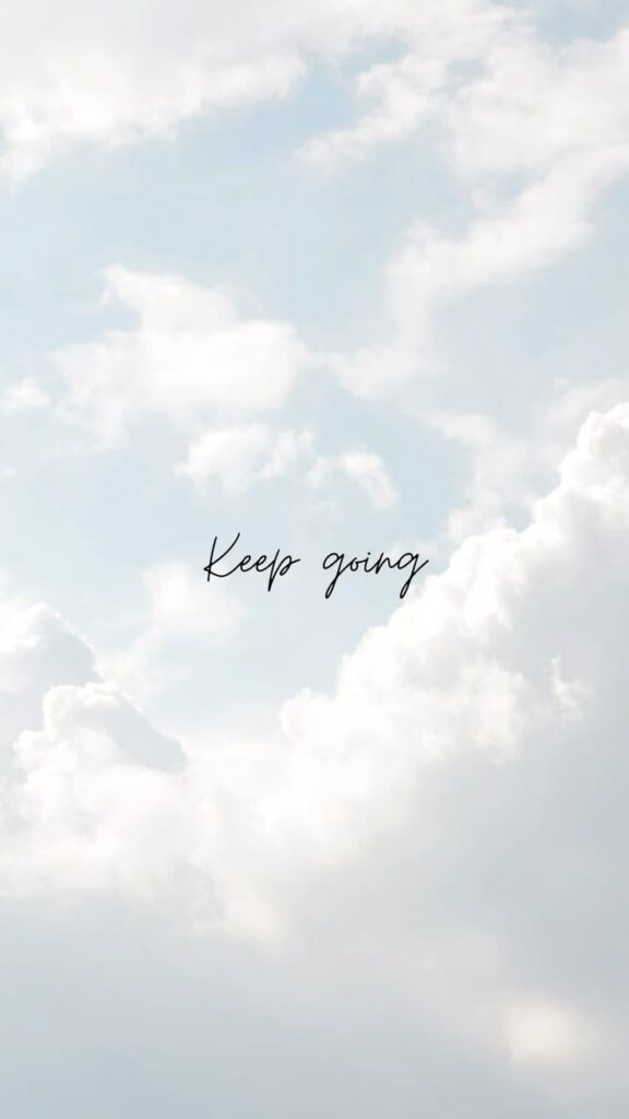 Keep going quote on soft blue sky with fluffy white clouds — motivational phone wallpaper and inspirational background