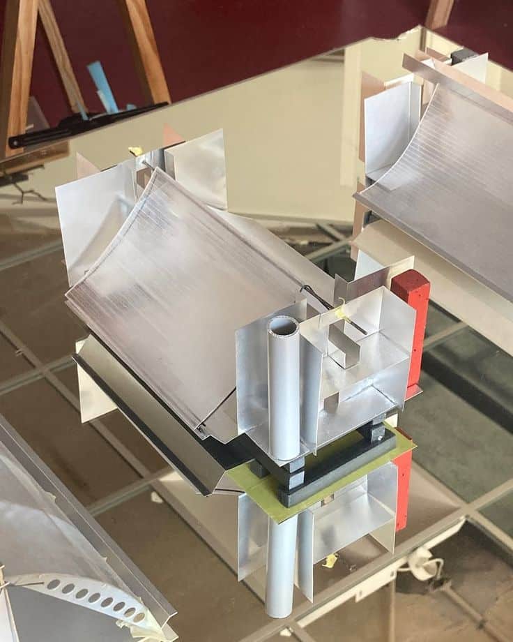 Architectural model showcasing complex geometric structures with reflective surfaces.