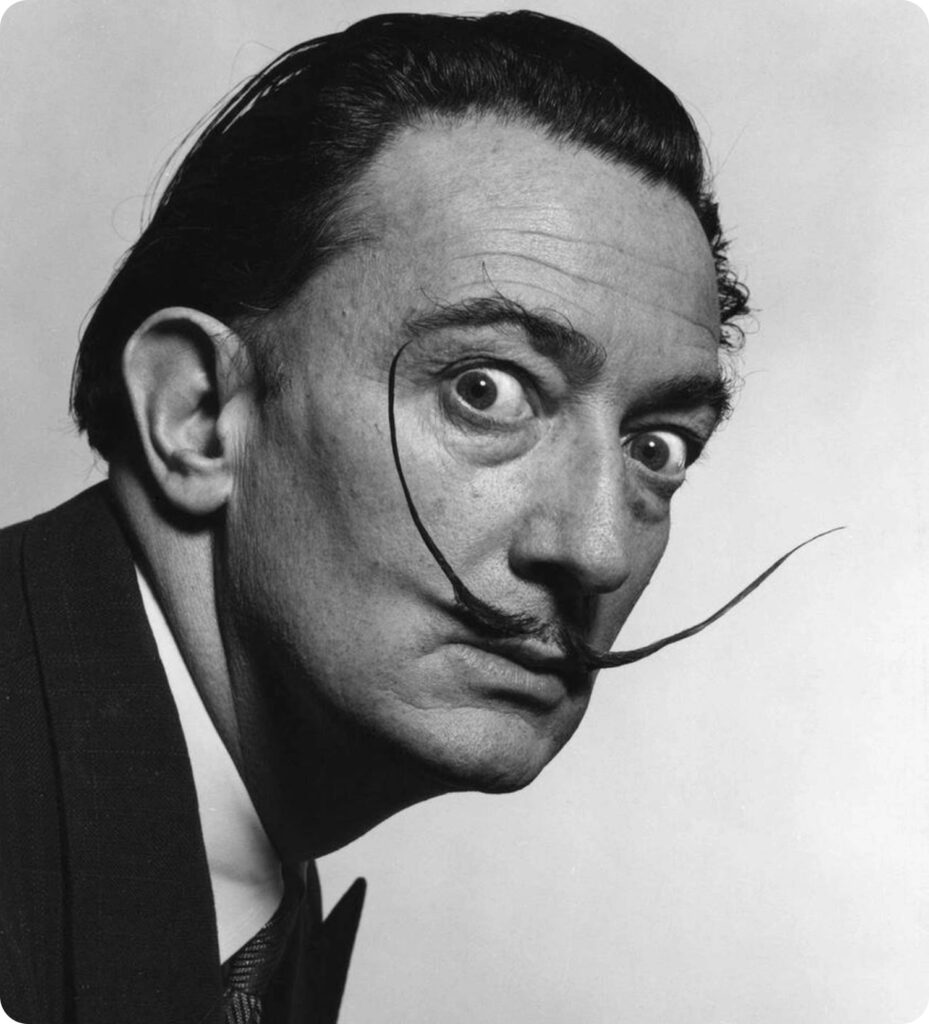 Black-and-white close-up portrait of a wide-eyed man with dramatic upturned mustache, vintage style