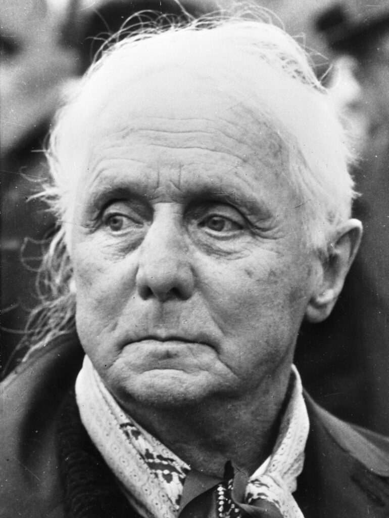Black-and-white close-up portrait of an elderly man with white hair, deep wrinkles and a patterned scarf