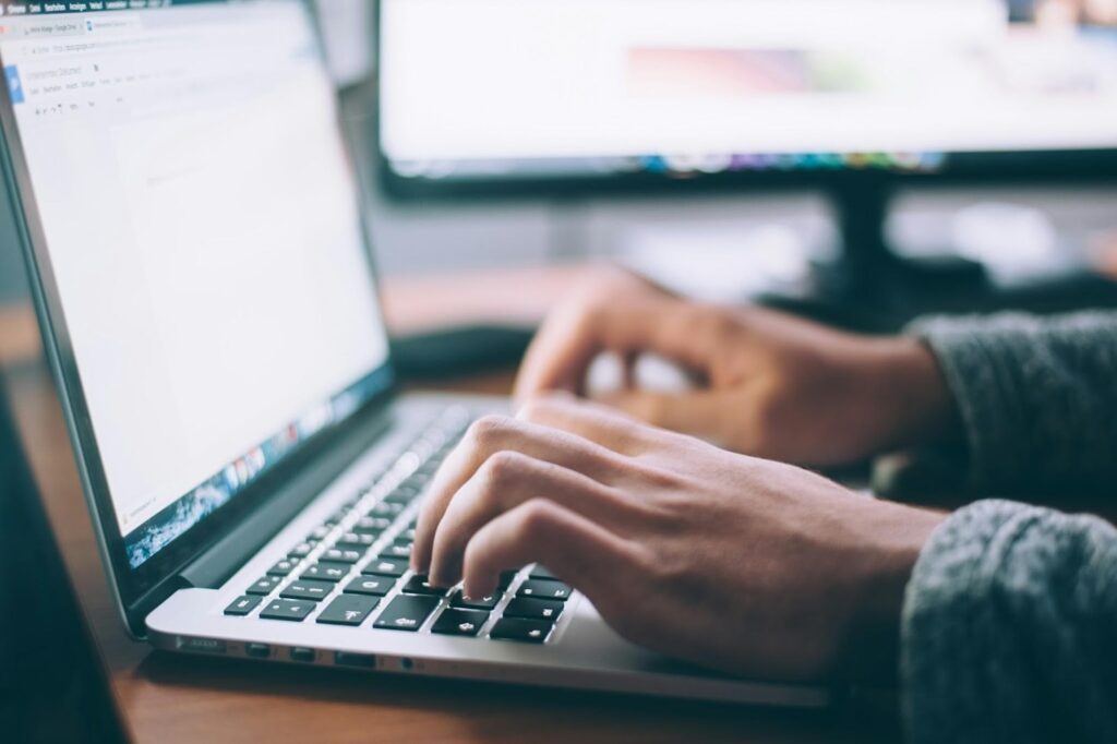 unnamed Hands typing on a laptop keyboard, focusing on productivity and online work in a modern workspace. | Sky Rye Design Hands typing on a laptop keyboard, focusing on productivity and online work in a modern workspace.
