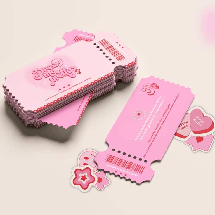 Pink custom event tickets with decorative designs, surrounded by flower and heart-shaped stickers on a neutral background.