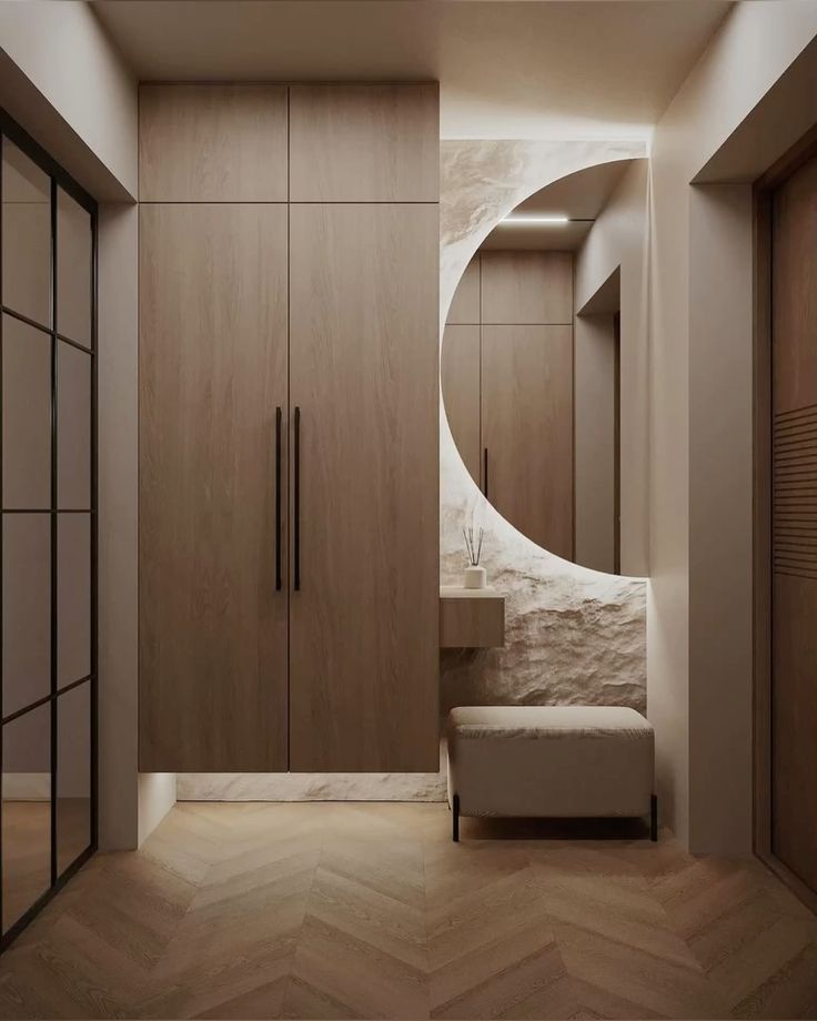 Modern hallway with wooden cabinets, round mirror, bench, and herringbone floor. Minimalist interior design.