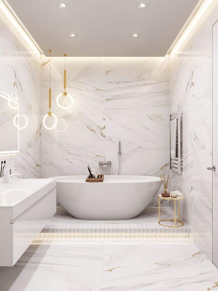 Luxurious marble bathroom with freestanding tub, modern pendant lights, and sleek decor accents.
