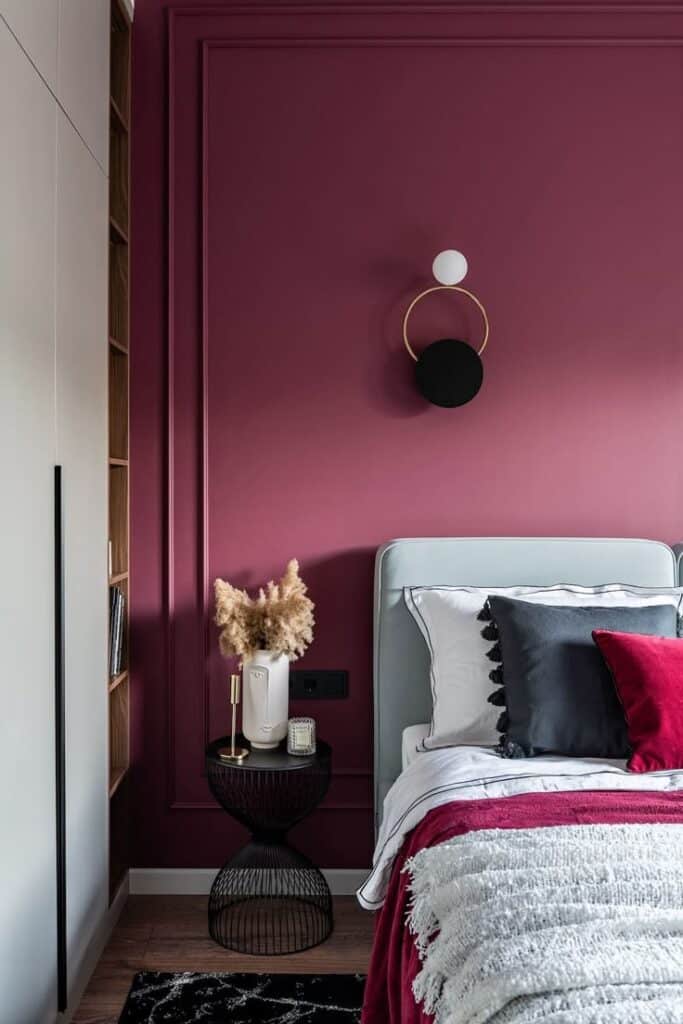 Modern bedroom with burgundy wall, stylish decor, and chic black and white bedding for a cozy ambiance.