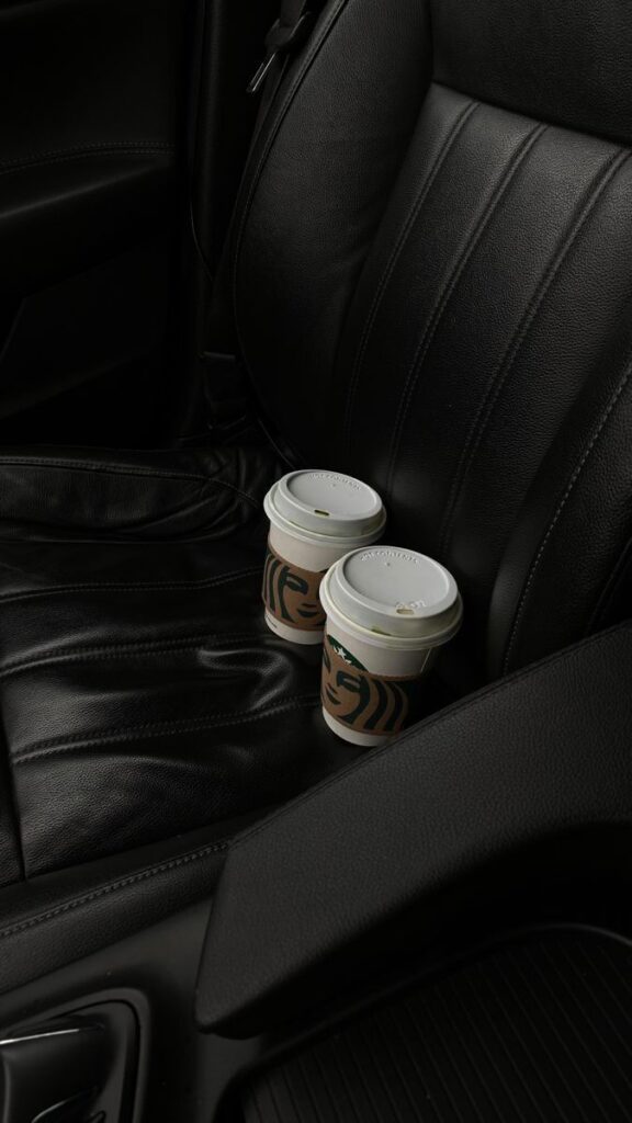 Two coffee cups on a car seat, ready for a drive with your favorite brew.