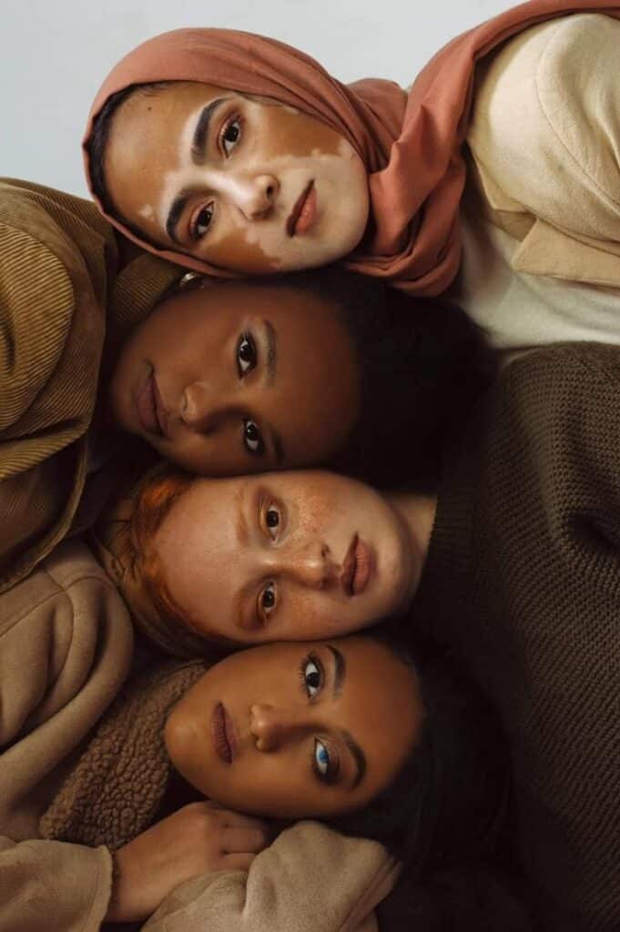 Four diverse women embracing unity and beauty, showcasing individuality and friendship.