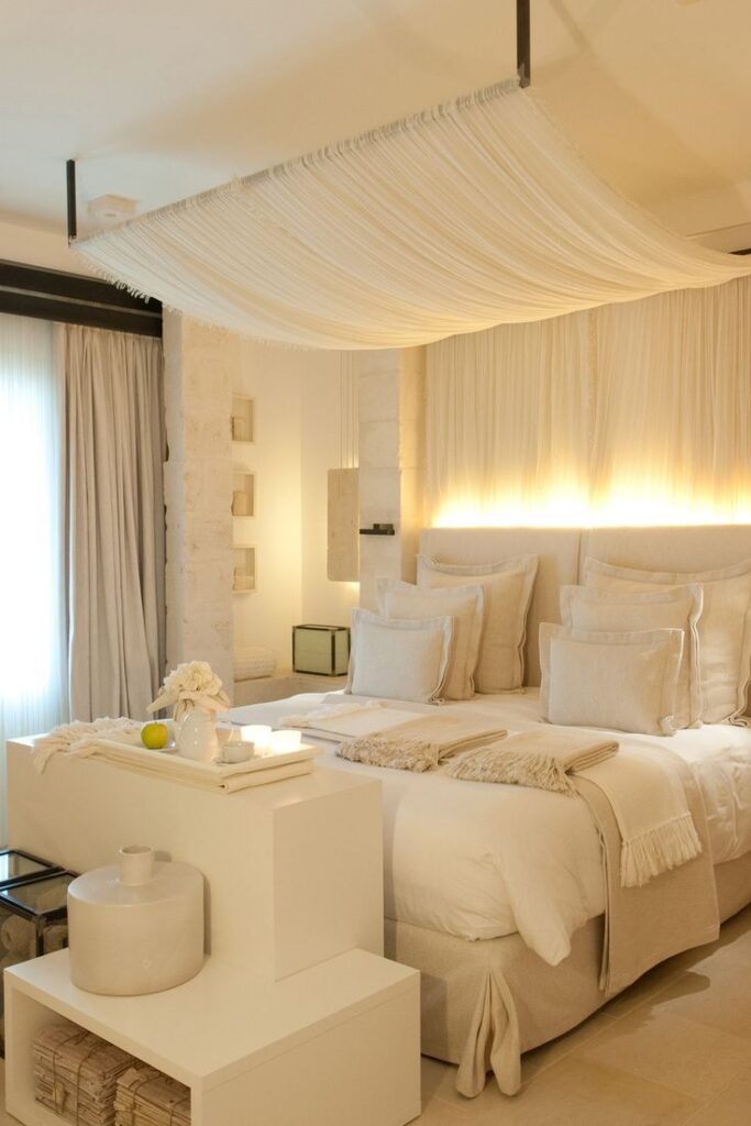 Elegant bedroom with canopy bed, soft lighting, and minimalist decor in neutral tones. Cozy and serene atmosphere.
