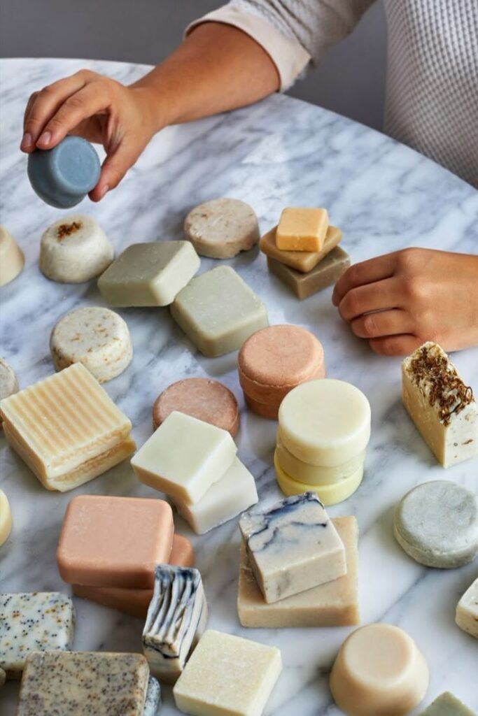 Assorted handmade soap bars on a marble table, showcasing vibrant colors and varied shapes for bath and beauty.
