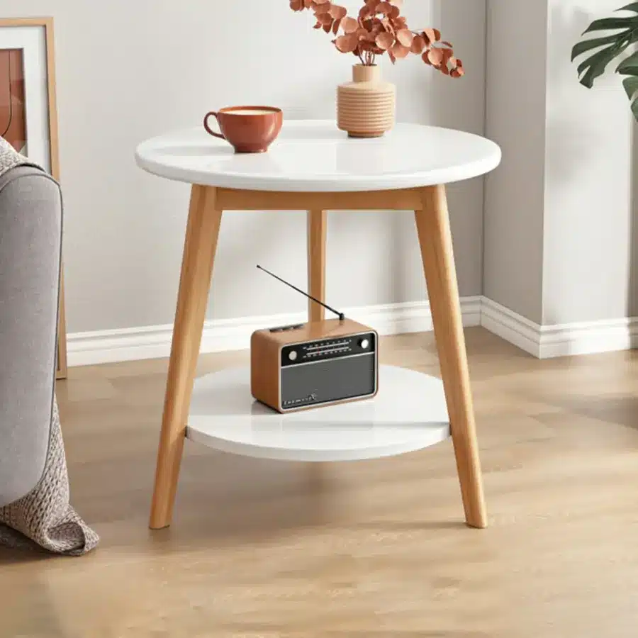 Modern side table with retro radio, cup, and vase in cozy living room setting.