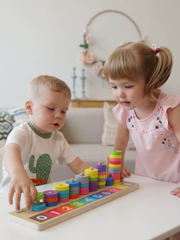 Children playing with a colorful educational stacking toy at home.