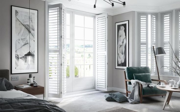 Modern bedroom with grey tones, open shutters, stylish decor, and natural light creating a serene, inviting atmosphere.