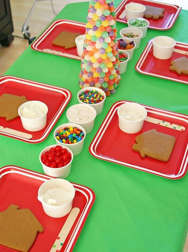 Gingerbread decorating party setup with candy toppings and a gumdrop tree on a festive table.