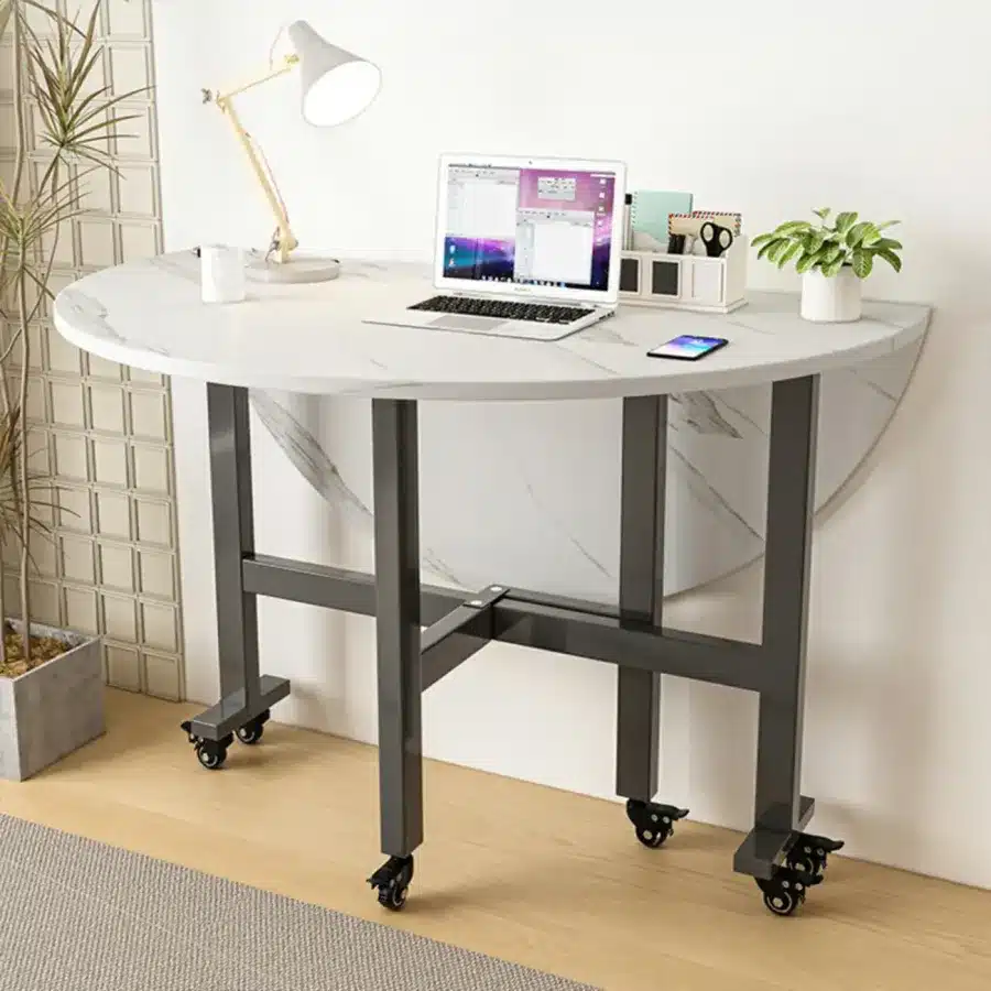 Foldable desk with laptop, lamp, and plant in modern office corner, perfect for small spaces and minimalistic design.