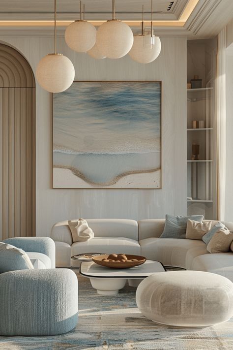 Modern living room with blue and beige decor, abstract beach painting, and round pendant lighting. Cozy and elegant ambiance.