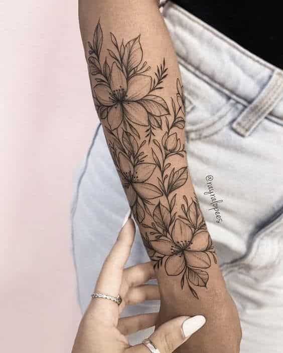 120 Pretty And Girly Half-Sleeve Tattoo Ideas For Females Stylish floral sleeve tattoo on forearm with intricate black linework, paired with light blue jeans. | Sky Rye Design Stylish floral sleeve tattoo on forearm with intricate black linework, paired with light blue jeans.