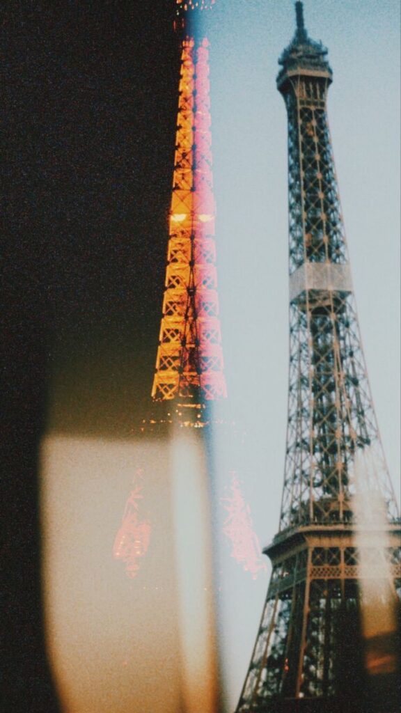 Double exposure of the Eiffel Tower, blending day and night views in a creative, artistic photograph.
