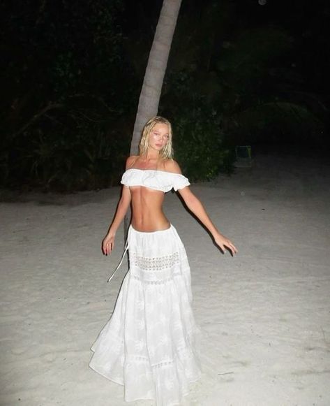 15149730-8b8e-4054-b379-734b5a7c283f Woman in a white dress posing at night on a sandy beach with palm trees. | Sky Rye Design Woman in a white dress posing at night on a sandy beach with palm trees.