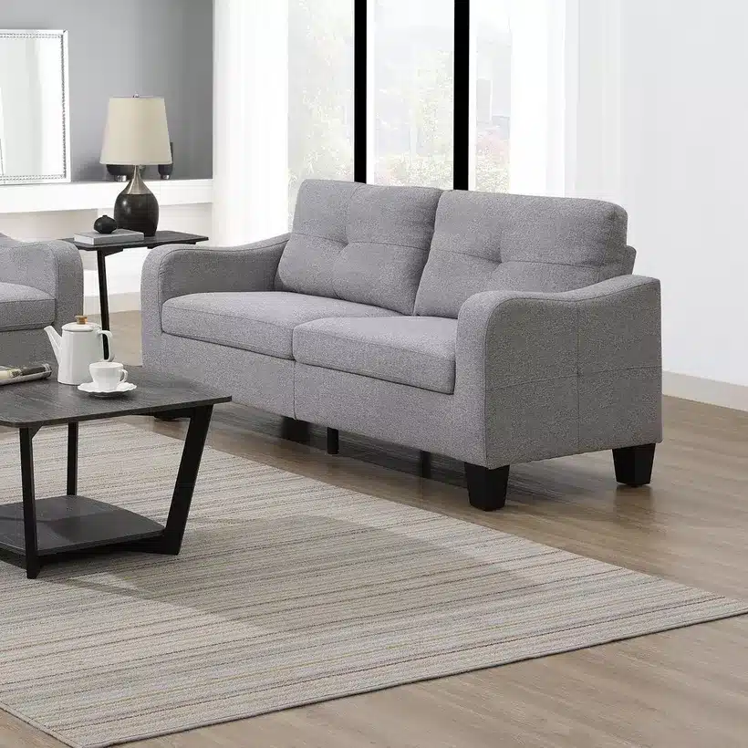 Modern gray sofa in bright living room with coffee table and stylish decor.